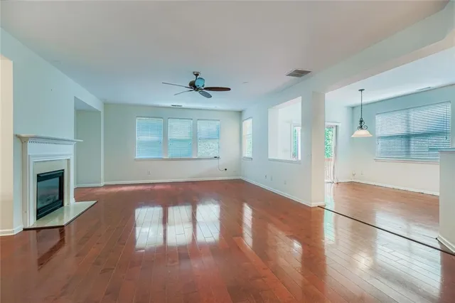 a view of an empty room with a fireplace and wooden floor