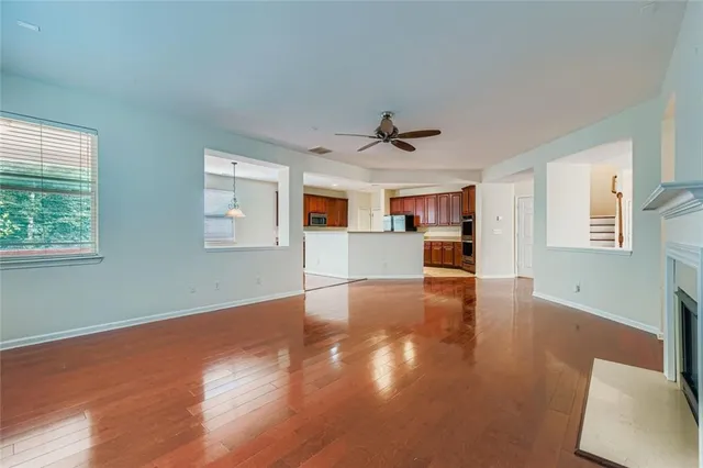 a view of empty room with wooden floor and window