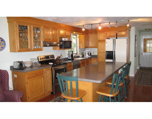 61 Clark Road Sturbridge, MA 01518 - Photo 4 of 17 a kitchen with stainless steel appliances kitchen island granite countertop a table chairs and a refrigerator