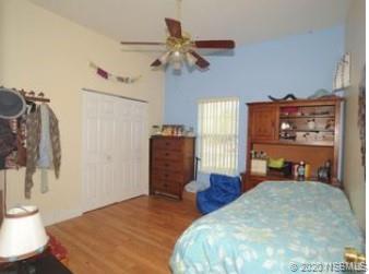 415 Stacy Grove Road Oak Hill, FL 32759 - Photo 19 of 25 a bed room with a bed and a chandelier
