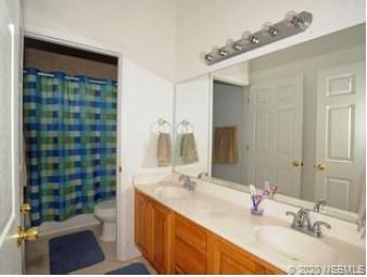 415 Stacy Grove Road Oak Hill, FL 32759 - Photo 21 of 25 a bathroom with a double vanity sink toilet and shower