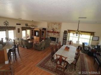 415 Stacy Grove Road Oak Hill, FL 32759 - Photo 10 of 25 a living room with lots of furniture and a chandelier