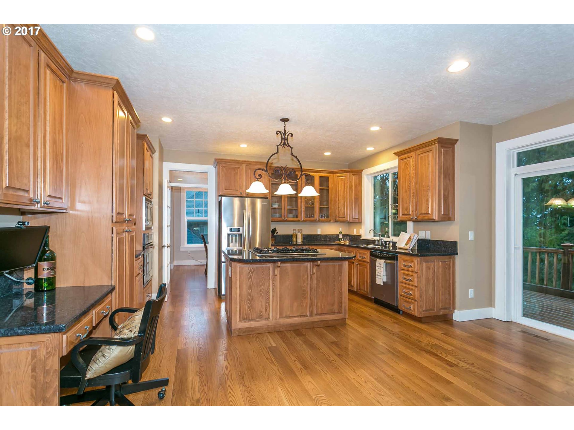 14525 Southeast Duke Street Portland, OR 97236 - Photo 10 of 27 a open kitchen with granite countertop a stove top oven a sink dishwasher a dining table and chairs with wooden floor