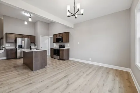 a view of kitchen with microwave stove top oven and cabinets
