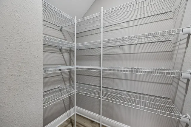 a view of walk in closet with empty racks