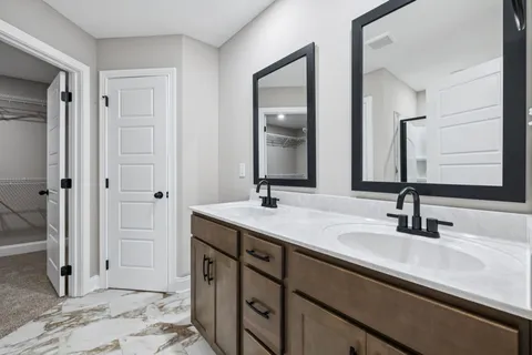 a bathroom with double vanity sinks and a mirror