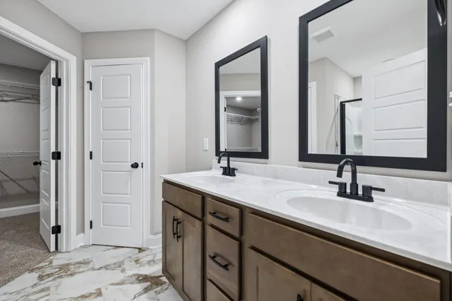 a bathroom with double vanity sinks and a mirror