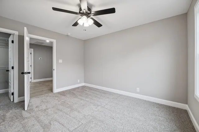 an empty room with a empty space and a ceiling fan