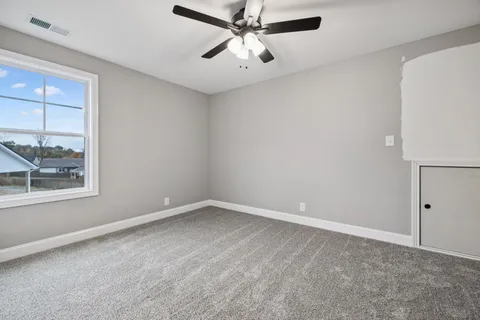 an empty room with a window and a fan