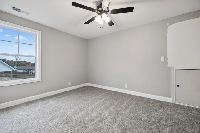 an empty room with a window and a fan