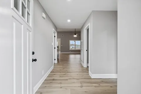 a view of a hallway with wooden floor and staircase