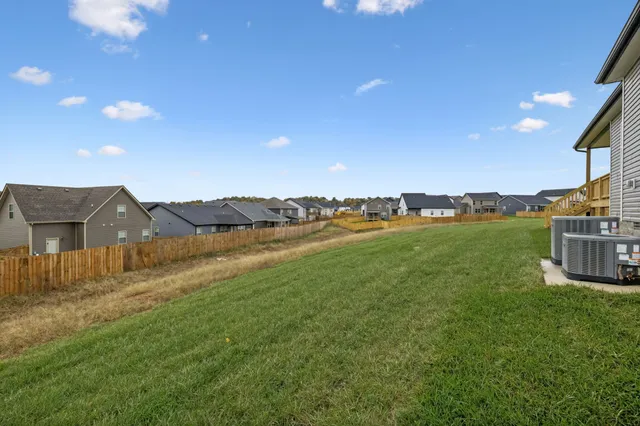 a view of a house with a yard and a pond
