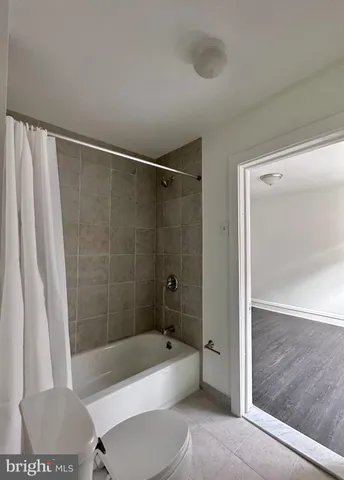 a bathroom with a bathtub a toilet and a shower