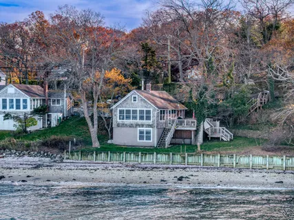 a view of a big house with a yard and large trees