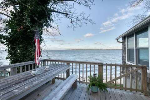 a terrace with wooden floor barbeque oven and yard in the back