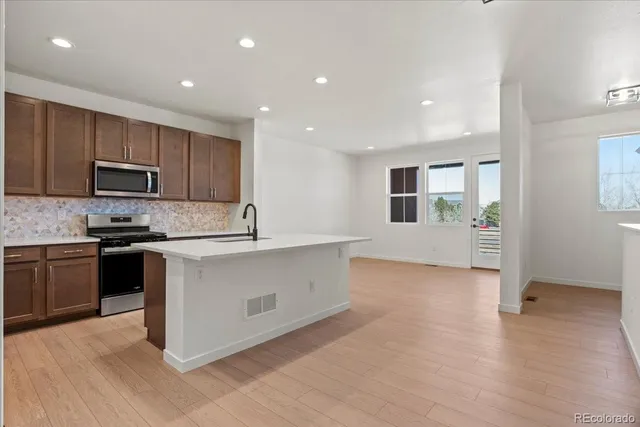 a kitchen with granite countertop a stove top oven and sink