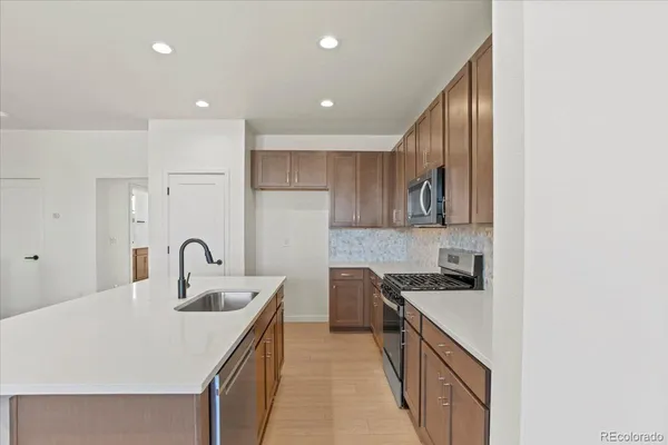 a kitchen with kitchen island granite countertop a sink and cabinets