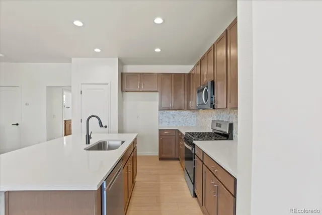 a kitchen with kitchen island granite countertop a sink and cabinets