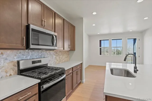 a kitchen with granite countertop a sink stove and microwave
