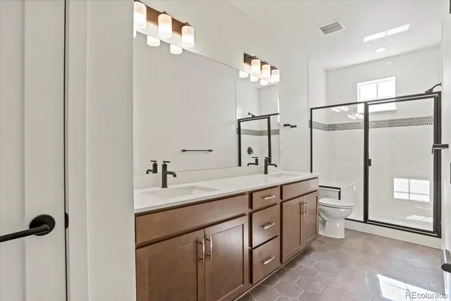 a bathroom with a double vanity sink a toilet and a mirror