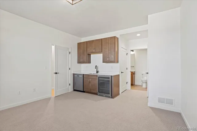 a large white kitchen with stainless steel appliances a sink and cabinets