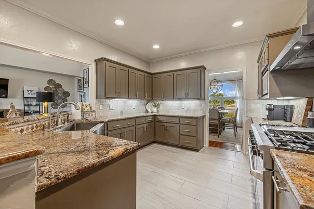 a kitchen with stainless steel appliances granite countertop a sink stove and refrigerator