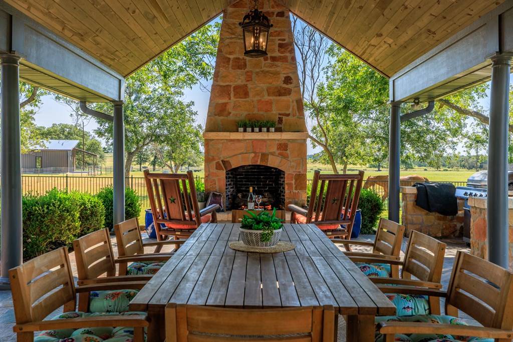 234 Nelson-rouse Road Fredericksburg, TX 78624 - Photo 27 of 41 a view of a patio with table and chairs potted plants with wooden floor and floor to ceiling window