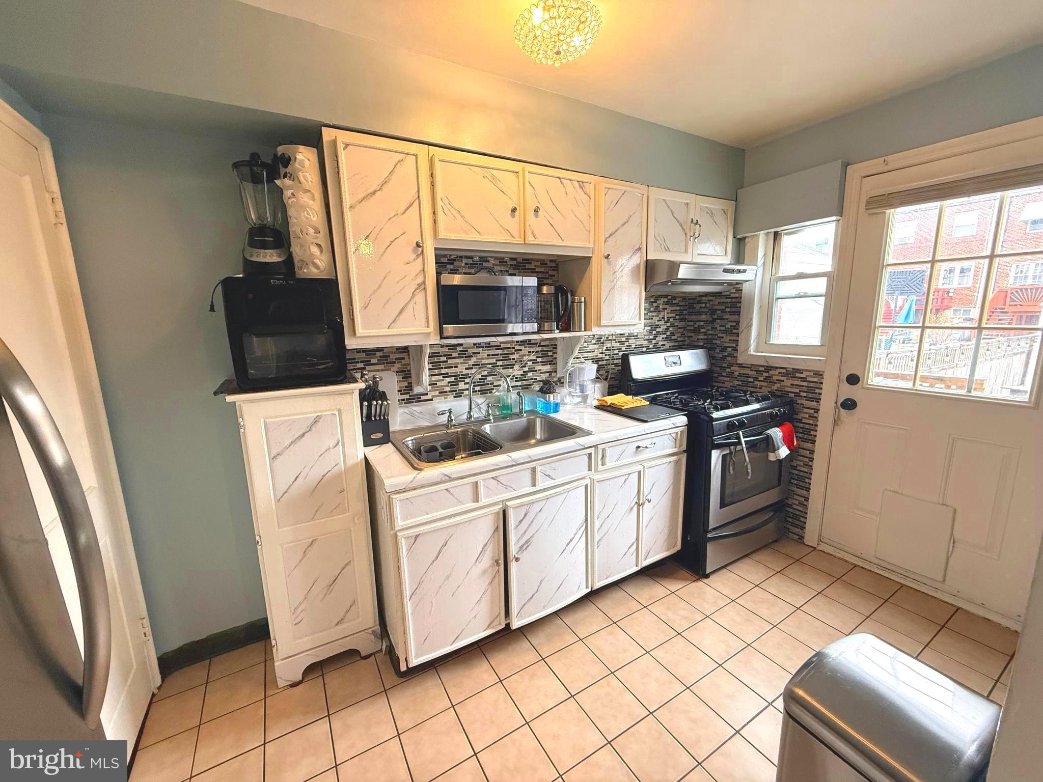 7820 Wynbrook Road Baltimore, MD 21224 - Photo 5 of 18 a kitchen with stainless steel appliances a stove a sink and a refrigerator