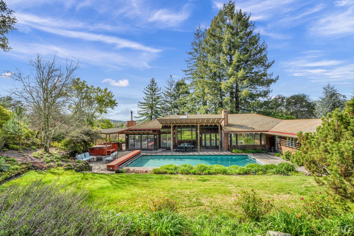 a view of a house with a big yard and large trees