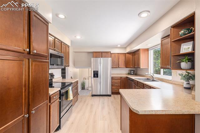 4514 Ridgeglen Road Colorado Springs, CO 80918 - Photo 11 of 29 Kitchen with stainless steel appliances, light countertops, light LVP flooring, open shelves, and recessed lighting