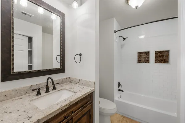 a bathroom with a granite countertop sink toilet and shower