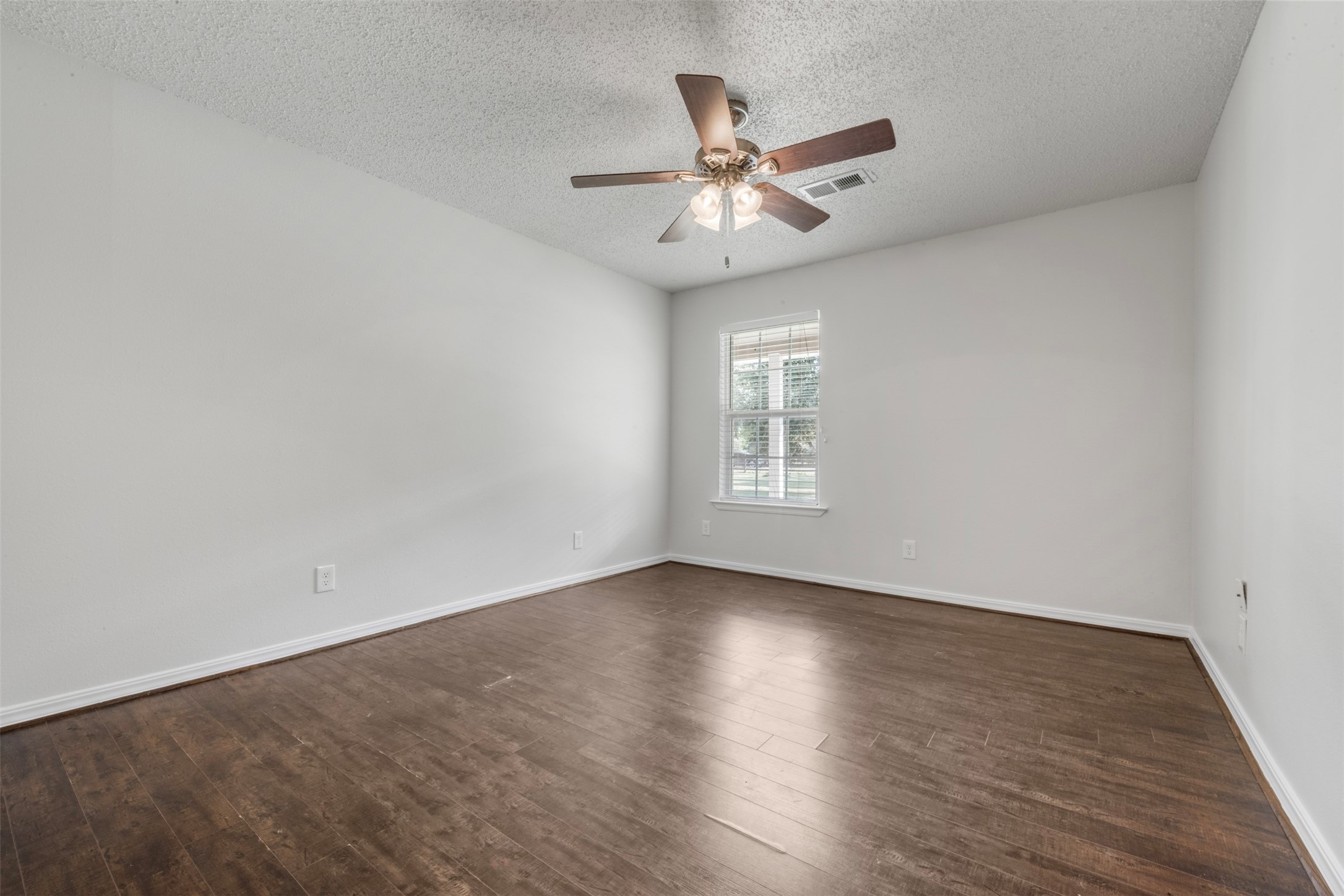 28081 Ivy Oaks Lane Splendora, TX 77372 - Photo 14 of 27 an empty room with wooden floor fan and windows