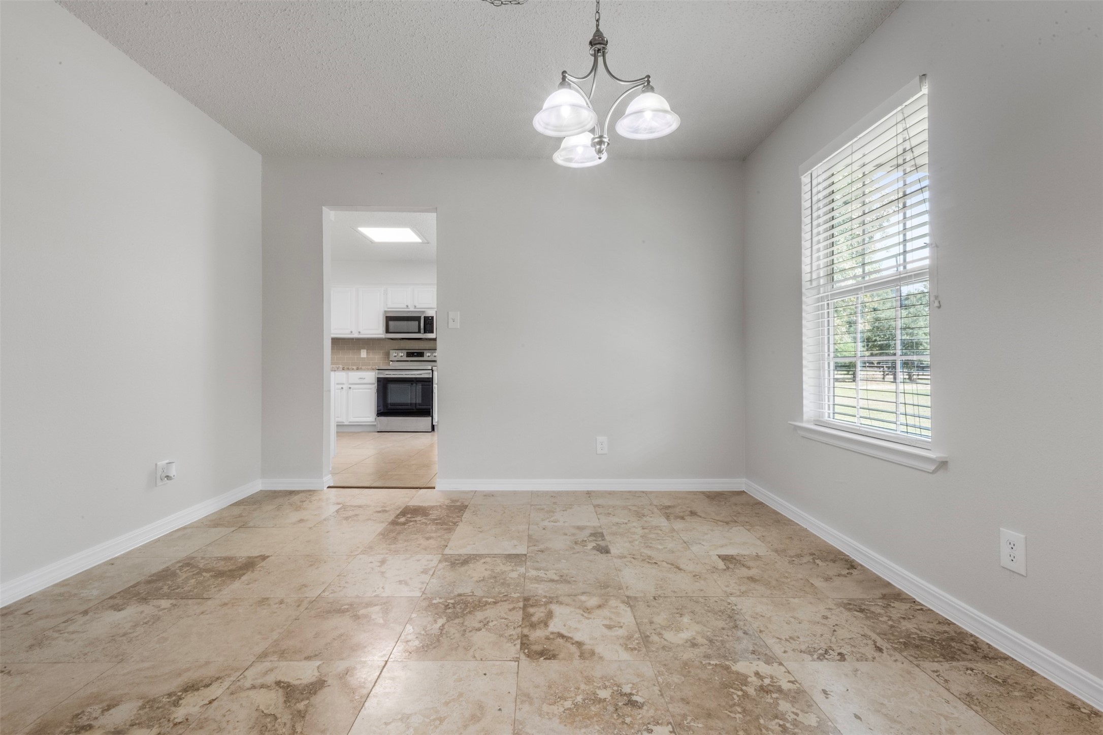 28081 Ivy Oaks Lane Splendora, TX 77372 - Photo 17 of 27 an empty room with chandelier and windows