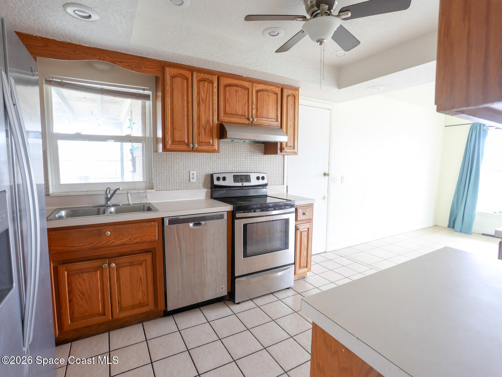 2375 Ricky Road Melbourne, FL 32935 - Photo 7 of 41 a kitchen with stainless steel appliances granite countertop a stove a sink and a refrigerator