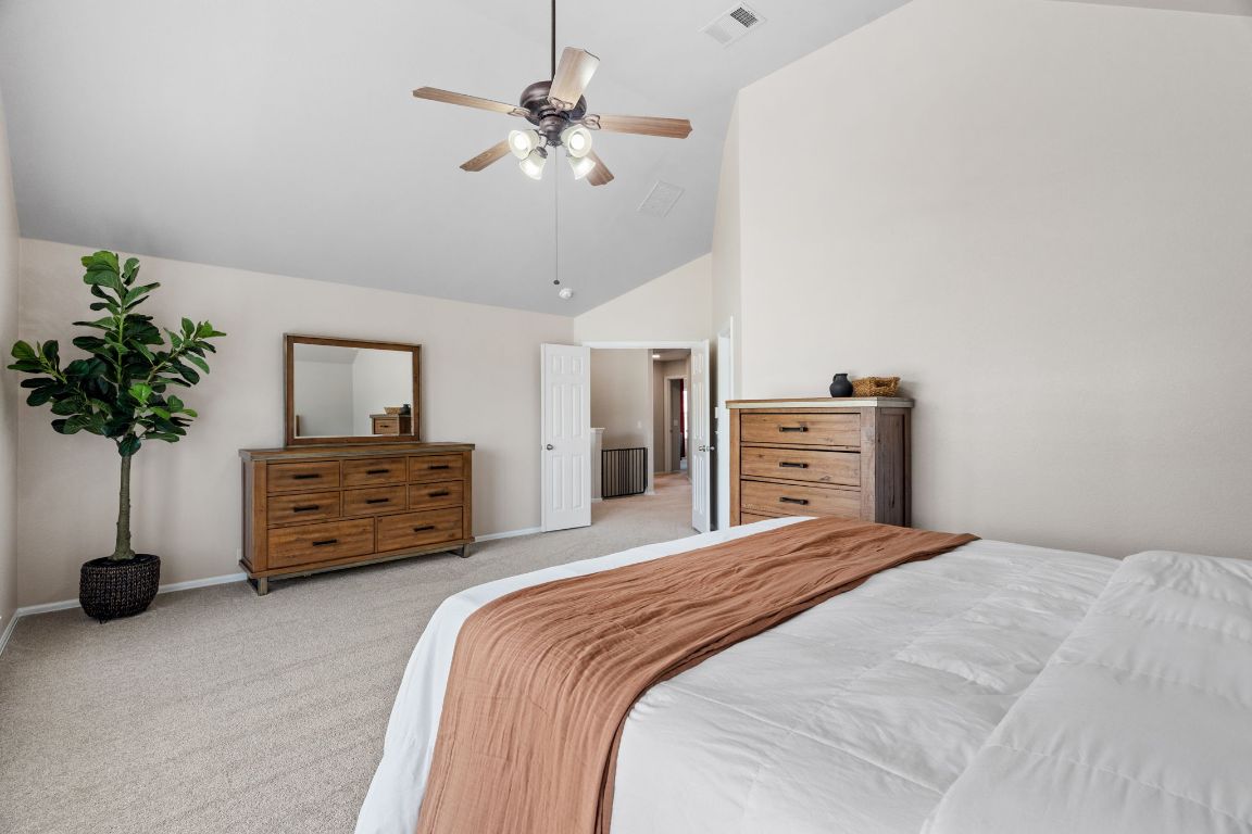 154 Larch Cove Kyle, TX 78640 - Photo 11 of 25 a bedroom with a bed and a chandelier