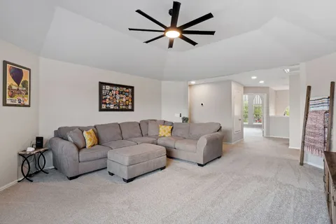a living room with furniture and a ceiling fan