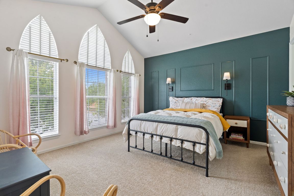 154 Larch Cove Kyle, TX 78640 - Photo 16 of 25 a bed room with a bed and a chandelier