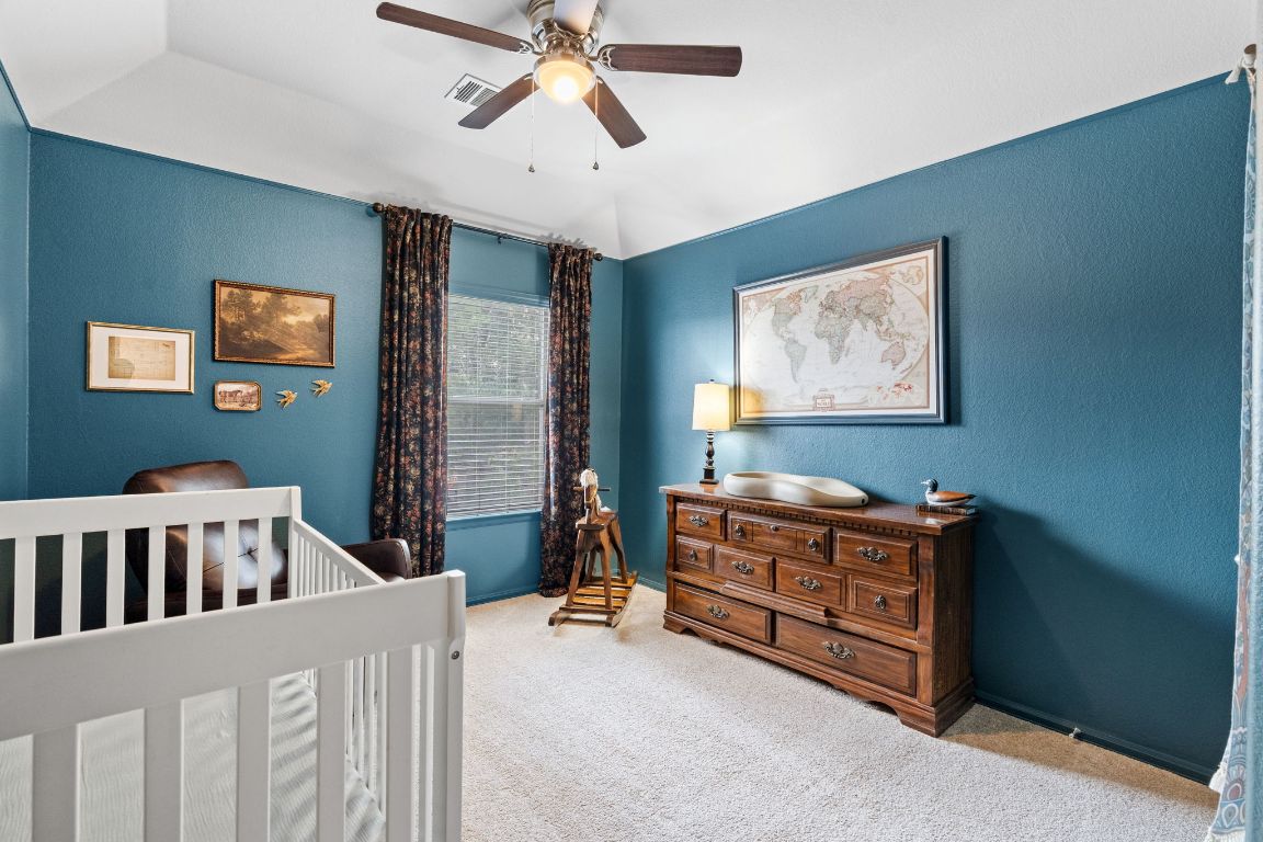 154 Larch Cove Kyle, TX 78640 - Photo 18 of 25 a bedroom with furniture and baby crib