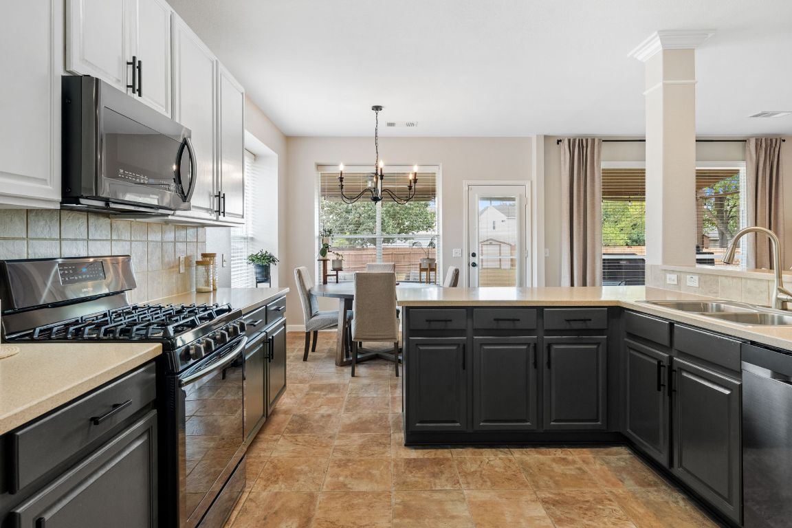154 Larch Cove Kyle, TX 78640 - Photo 8 of 25 a kitchen with a sink stove and microwave