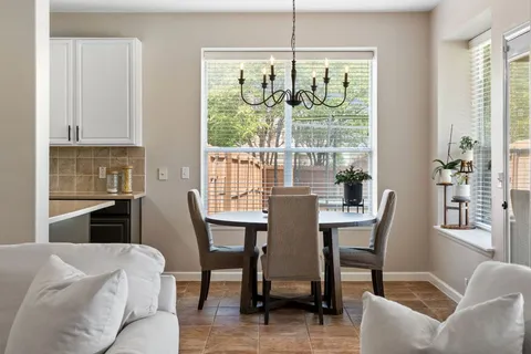 a dining room with furniture a chandelier and wooden floor
