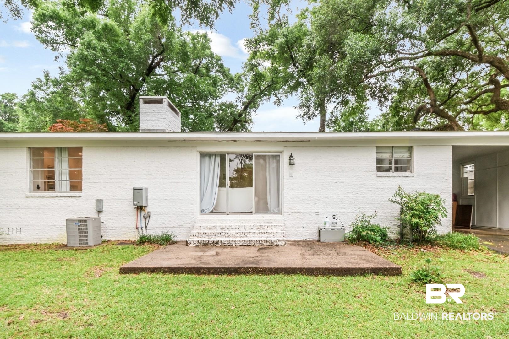 4596 Hawthorne Place Mobile, AL 36608 - Photo 31 of 34 Rear exterior with a white painted brick facade and a flat roofline