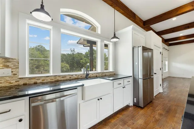 a dining hall with stainless steel appliances kitchen island granite countertop a dining table and chairs
