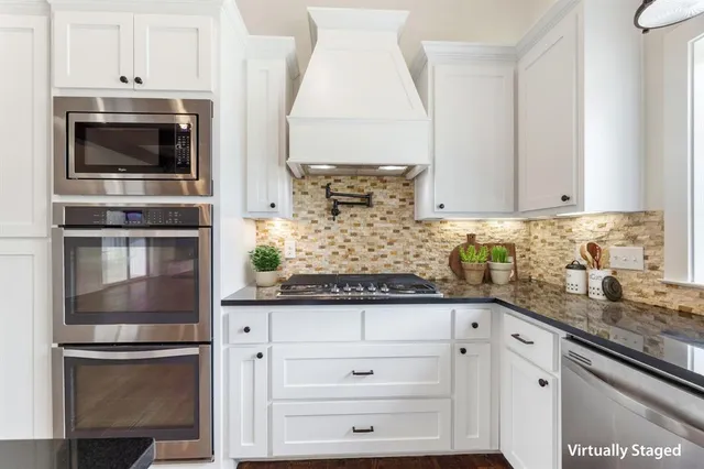a kitchen with granite countertop a sink and refrigerator