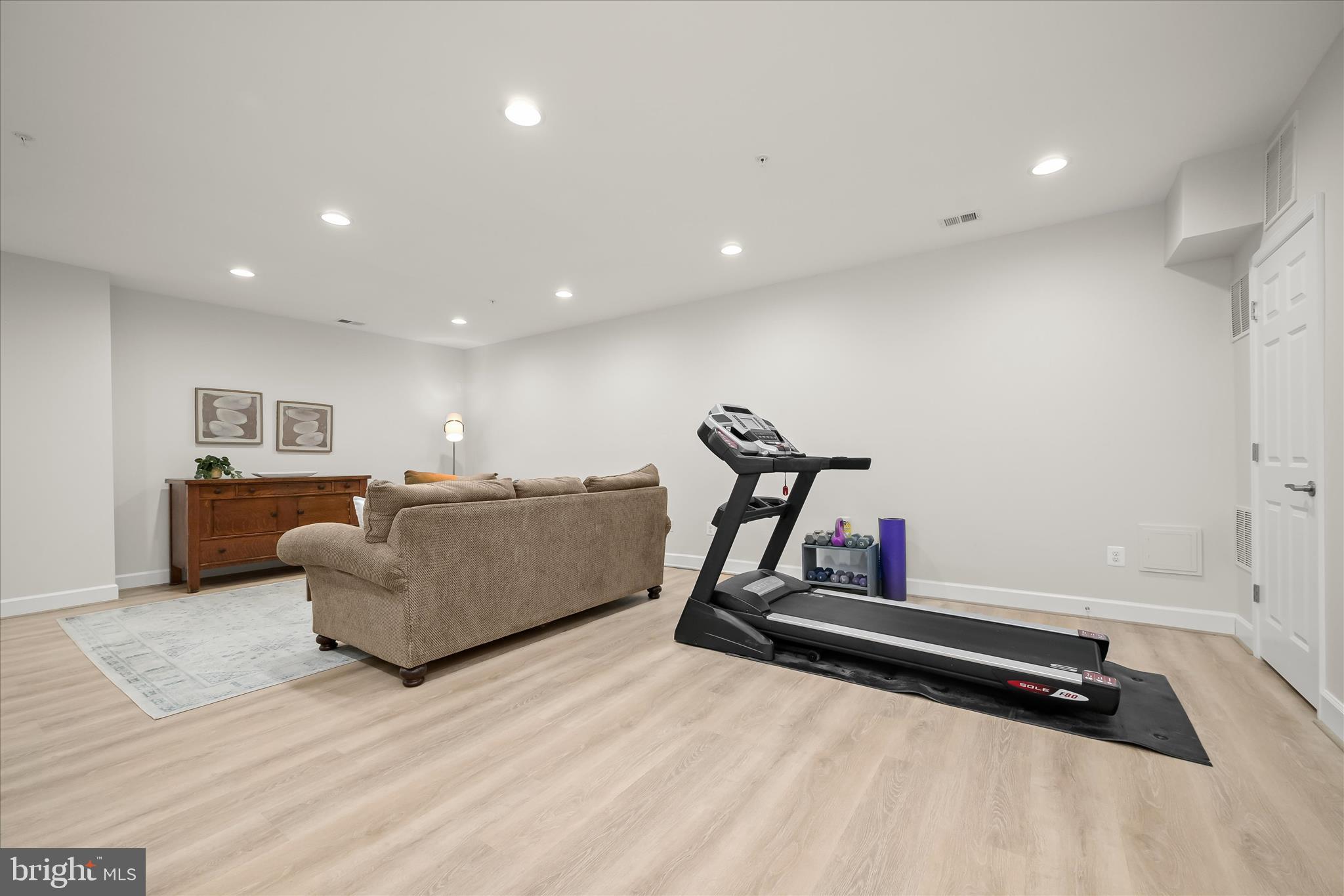 7905 Maple Lawn Boulevard Fulton, MD 20723 - Photo 37 of 49 a living room with furniture gym equipment and a wooden floor