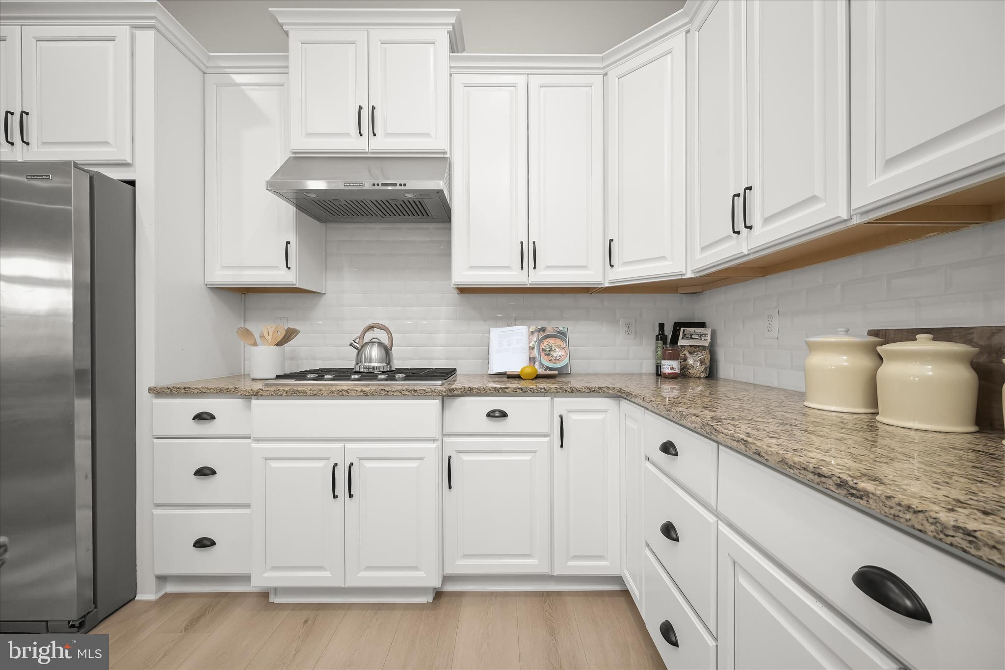 7905 Maple Lawn Boulevard Fulton, MD 20723 - Photo 10 of 49 a kitchen with granite countertop white cabinets and stainless steel appliances