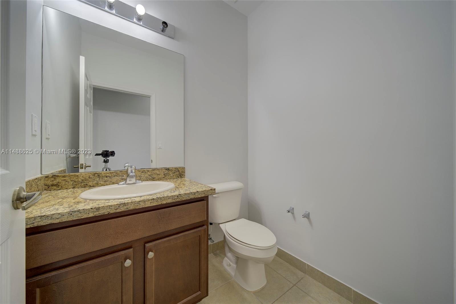 14679 Southwest 9th Street, Unit 1801 Pembroke Pines, FL 33027 - Photo 11 of 26 a bathroom with a granite countertop sink toilet and mirror