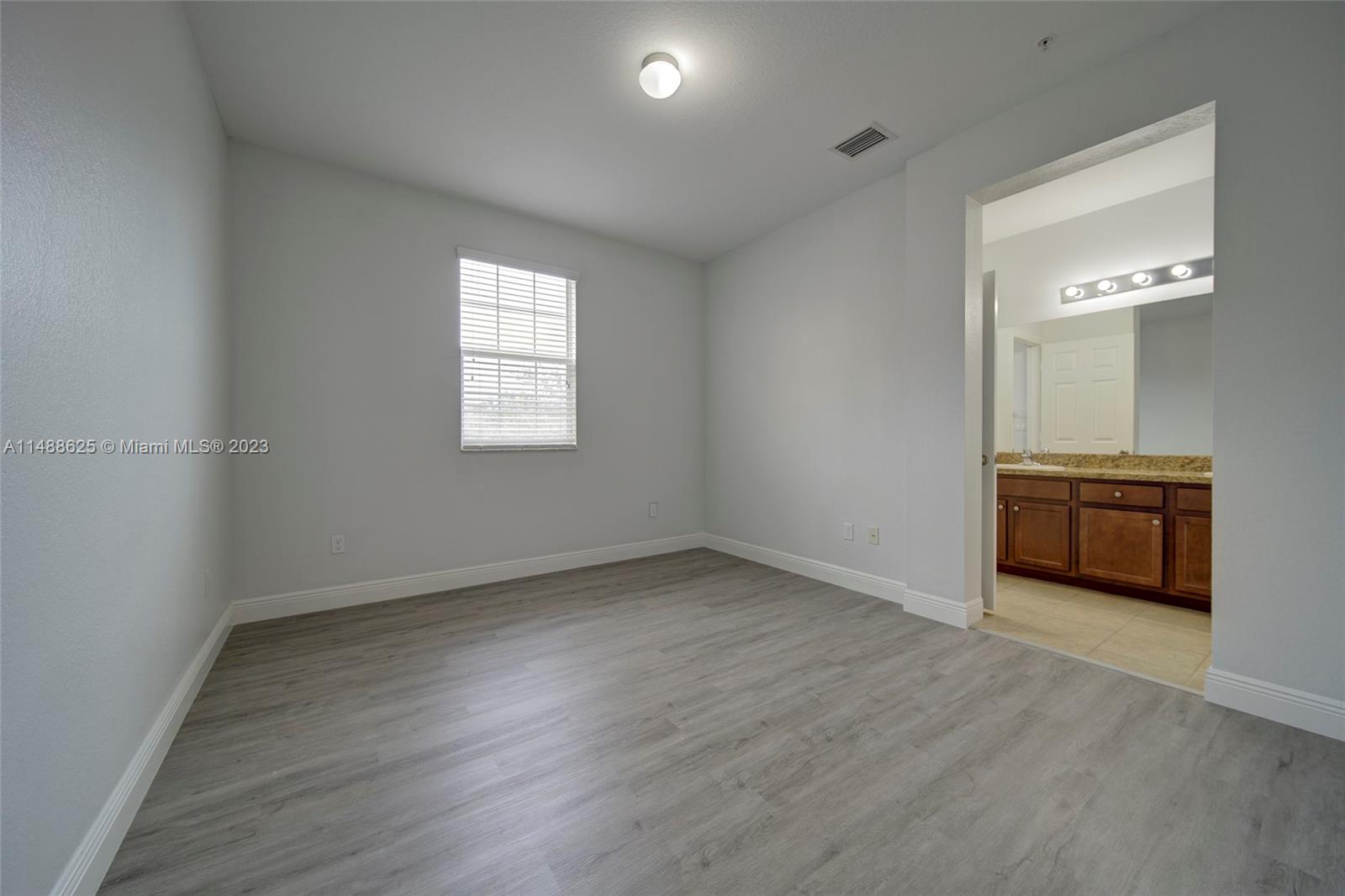 14679 Southwest 9th Street, Unit 1801 Pembroke Pines, FL 33027 - Photo 12 of 26 a view of an empty room with wooden floor and a window