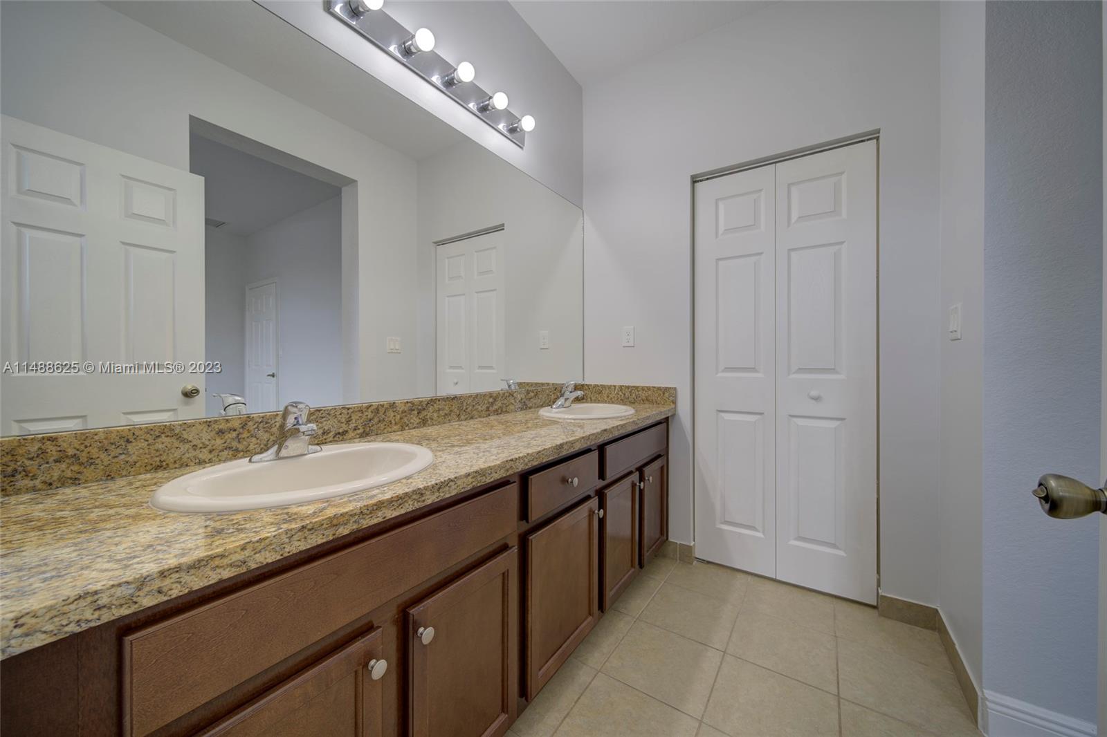 14679 Southwest 9th Street, Unit 1801 Pembroke Pines, FL 33027 - Photo 15 of 26 a bathroom with a granite countertop sink and a mirror