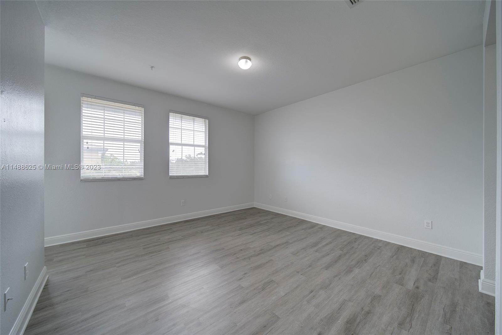 14679 Southwest 9th Street, Unit 1801 Pembroke Pines, FL 33027 - Photo 18 of 26 an empty room with wooden floor and windows