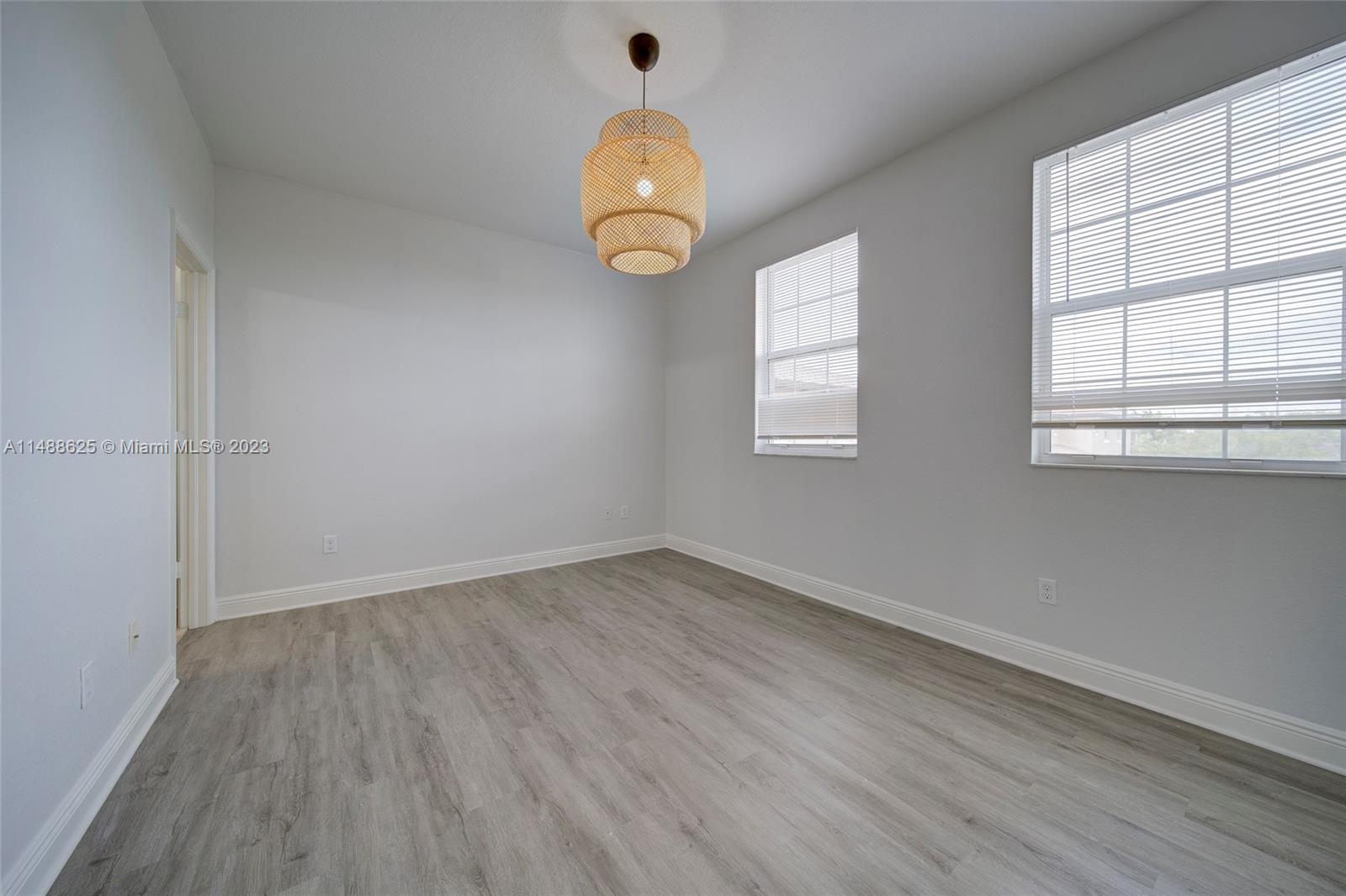 14679 Southwest 9th Street, Unit 1801 Pembroke Pines, FL 33027 - Photo 23 of 26 an empty room with wooden floor and windows